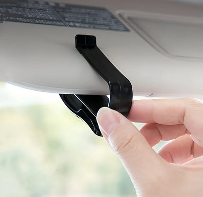 Black plastic clip for car sunshades to hold tickets, ID cards, or glasses.
