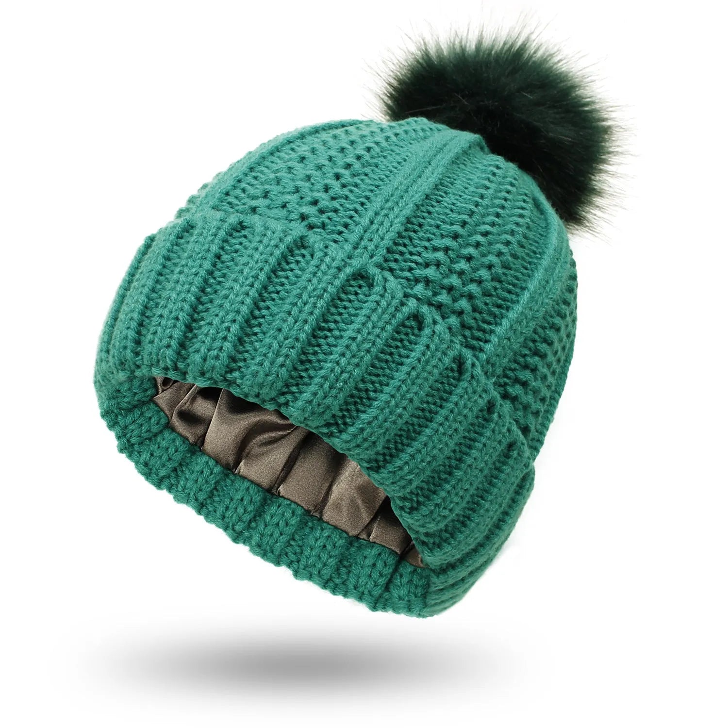 Woman wearing a wine red wool beanie hat with a faux fur pom pom and satin lining.