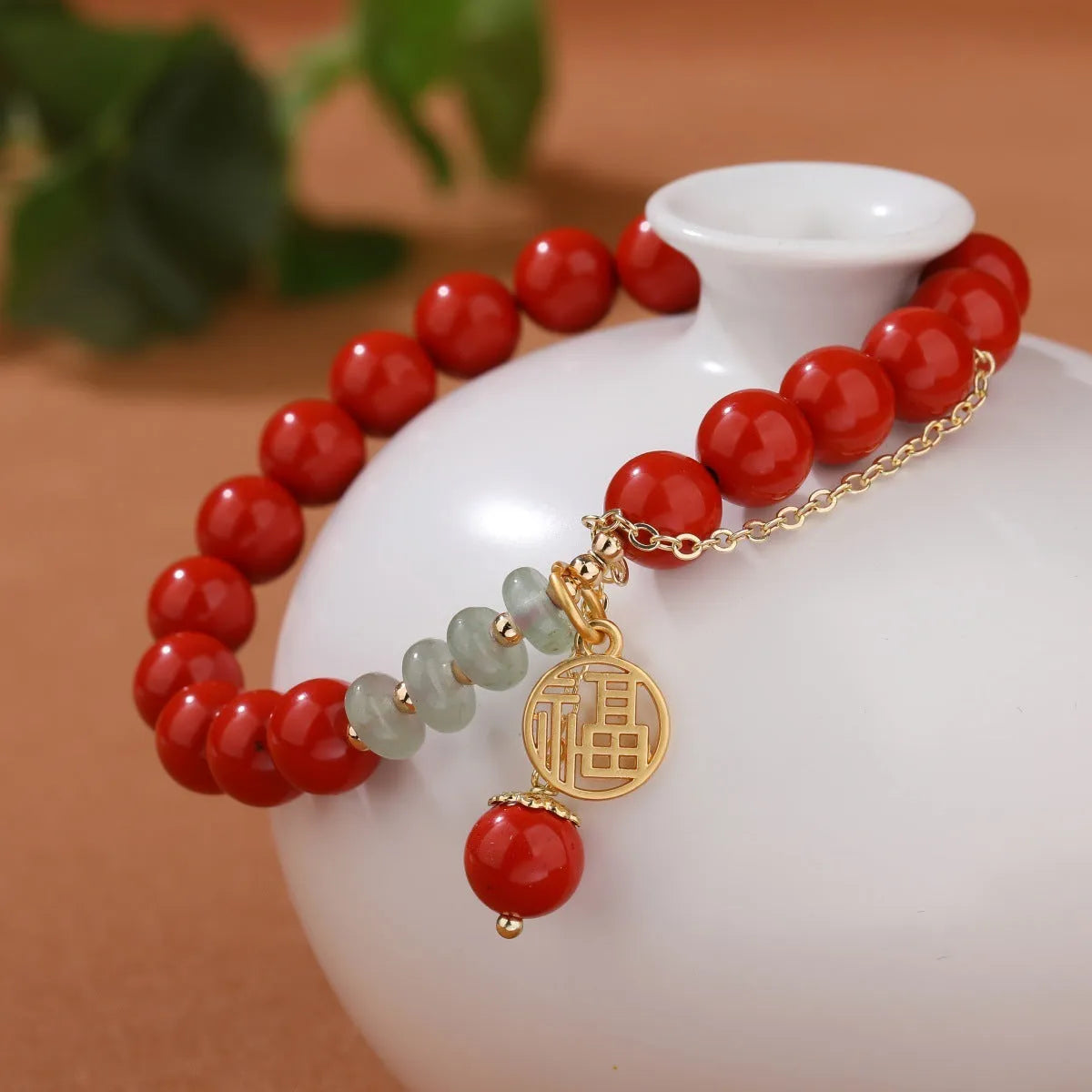 Retro women's bracelet with red cinnabar fu charm, jade bead, and tassel.