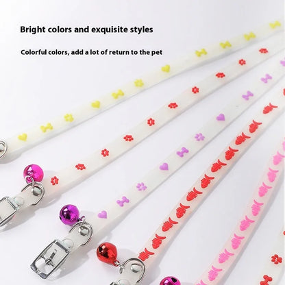 Glowing adjustable luminous collar for cats on a dark background, showing silicone chain and metal bell.