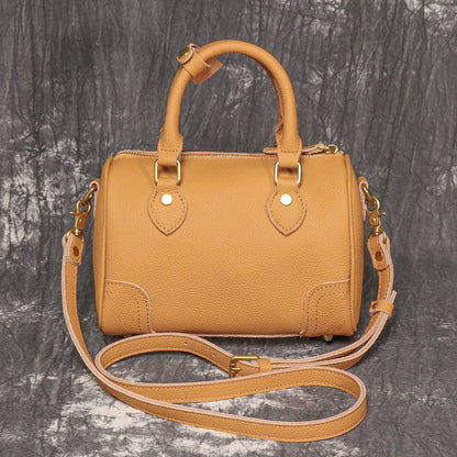 Handmade cylindrical brown Boston bag made from first layer cowhide leather with a single shoulder strap.
