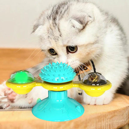 Cat playing with rotating windmill toy featuring luminous balls and suction base