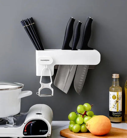 White modern plastic knife block holding six kitchen knives on a countertop.