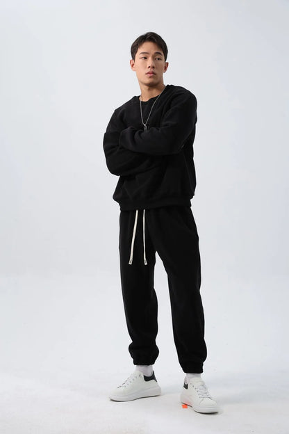 Man wearing a loose-fit army green polar fleece tracksuit with a crew neck jacket and matching padded trousers.