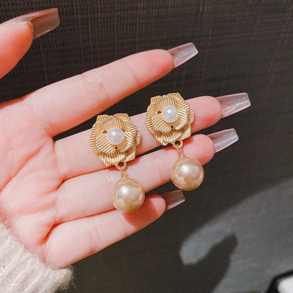 Gold-coloured floral stud earrings with a needle rose design, opal stone, and ice flower details.