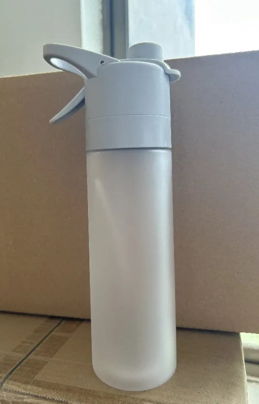 White spray water bottle with black leakproof lid and handle strap on a table