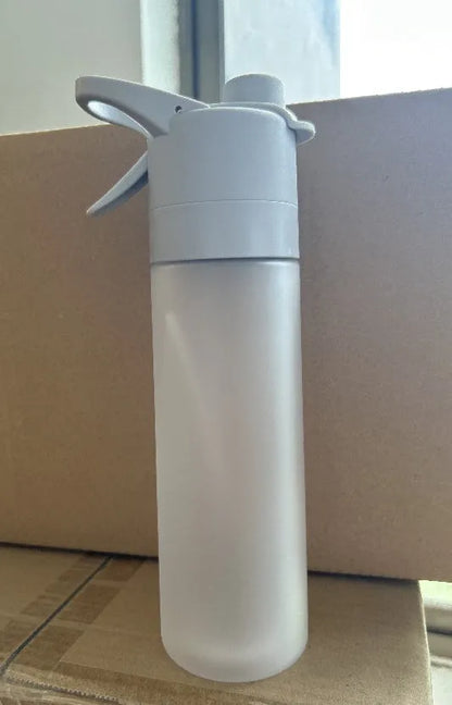 White spray water bottle with black leakproof lid and handle strap on a table