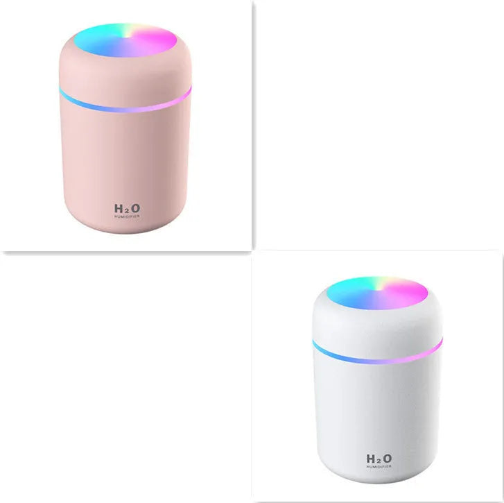 Pink USB desktop humidifier with LED lights and water tank on wooden desk