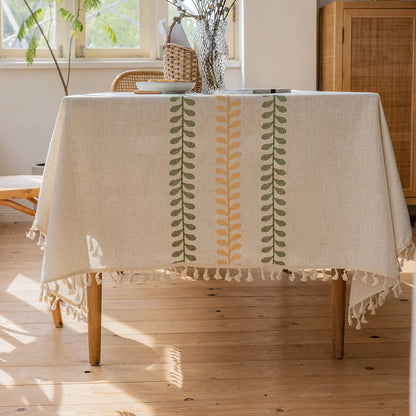 A beautifully embroidered tablecloth with a delicate floral and leaf pattern, perfect for dining and outdoor events.