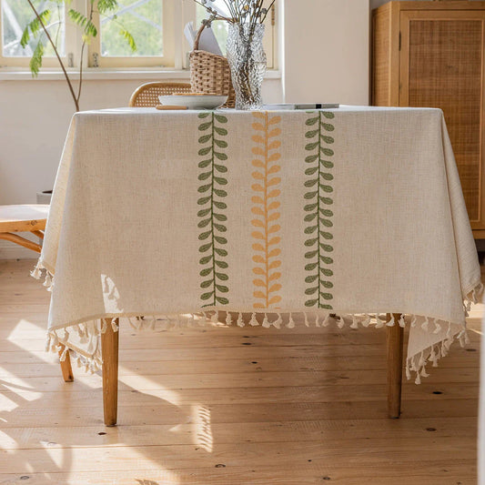 A beautifully embroidered tablecloth with a delicate floral and leaf pattern, perfect for dining and outdoor events.