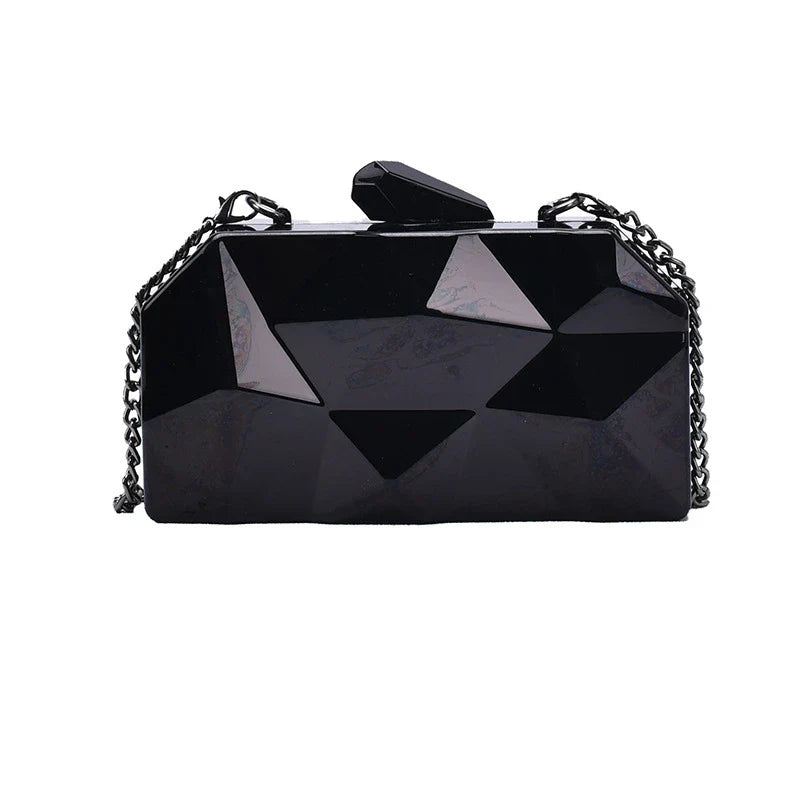 Elegant black leather handbag with a shimmering diamond-inspired chain strap, a timeless accessory for the modern British fashionista.
