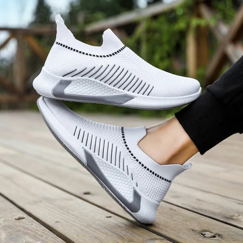 Men's black and white striped slip-on sneakers with lace-up front and mesh upper.