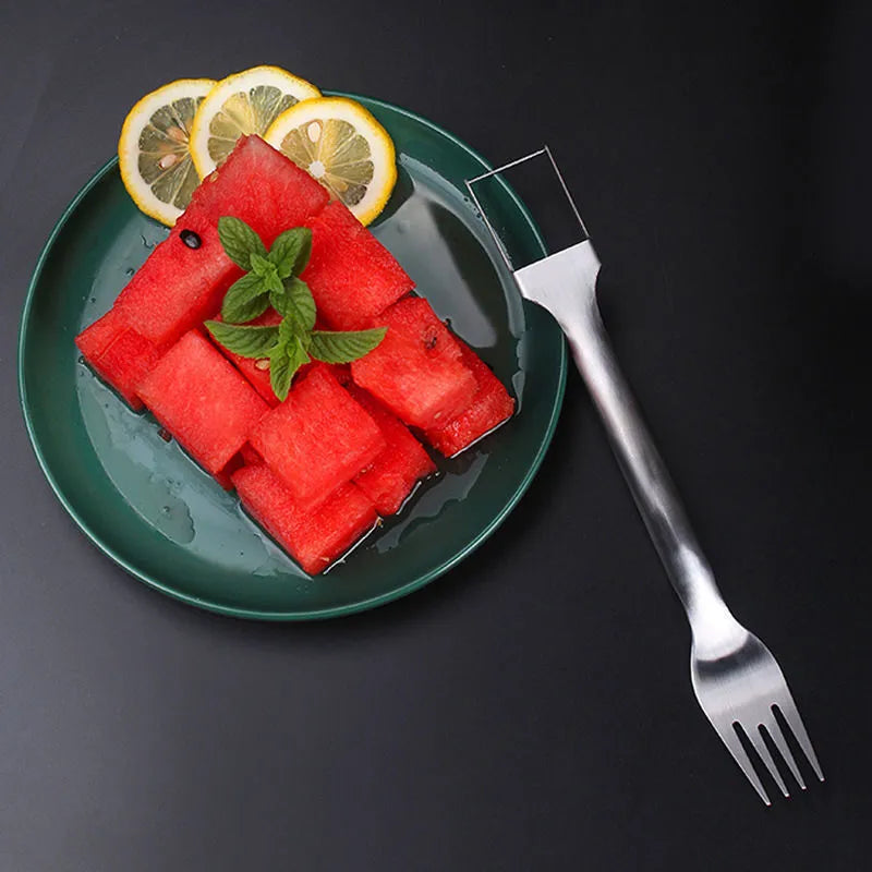 Stainless steel watermelon slicer and serving fork on a kitchen counter.