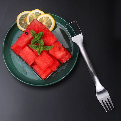 Stainless steel watermelon slicer and serving fork on a kitchen counter.