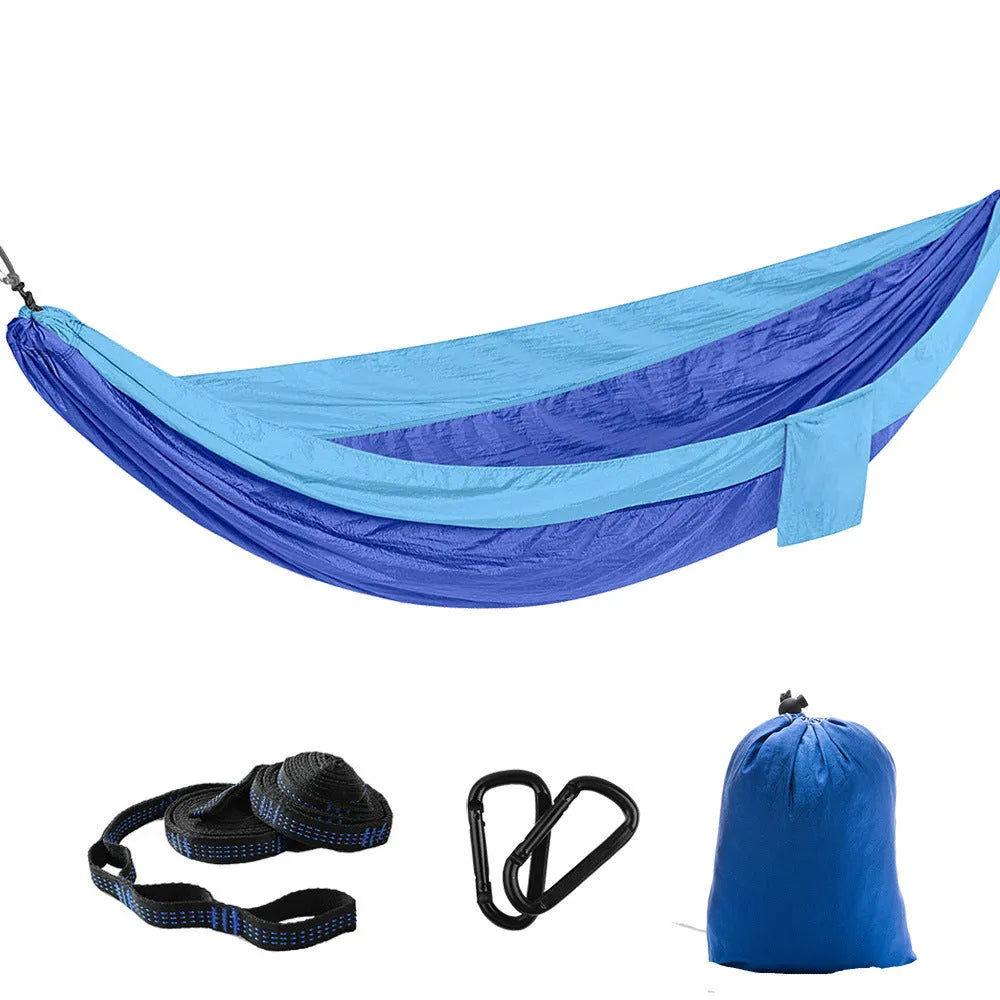 Parachute cloth double camping hammock in chosen colour, with black buckles and round ropes on a tree.
