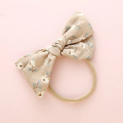 Children's cloth hair band with knotted bow design in one of six colour options