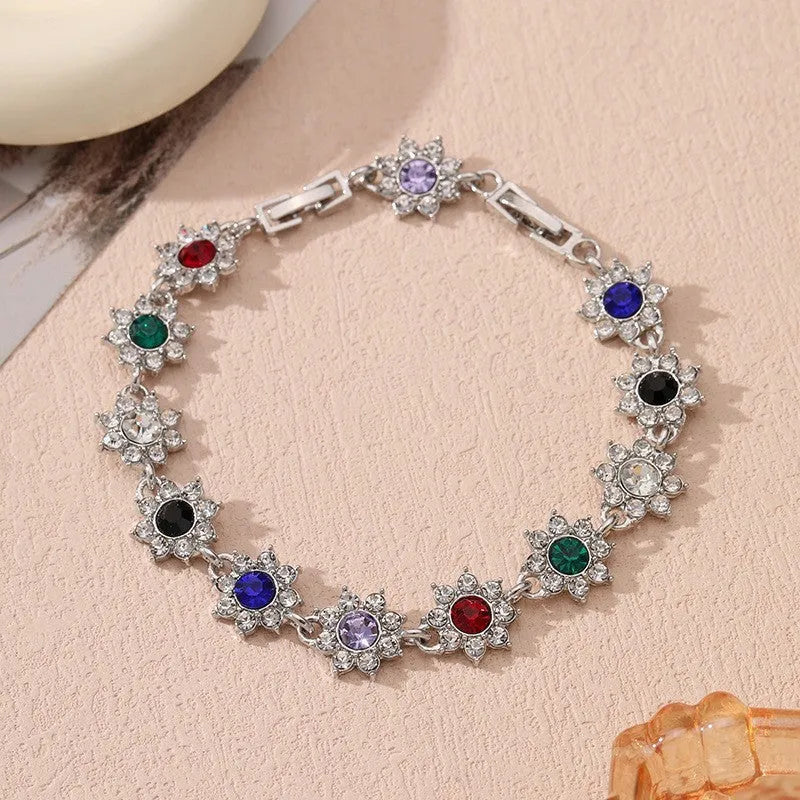 Gold and silver electroplated bracelets with flower charms set with coloured gemstones.