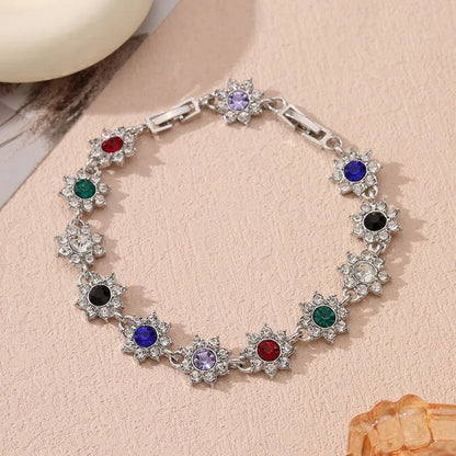 Gold and silver electroplated bracelets with flower charms set with coloured gemstones.