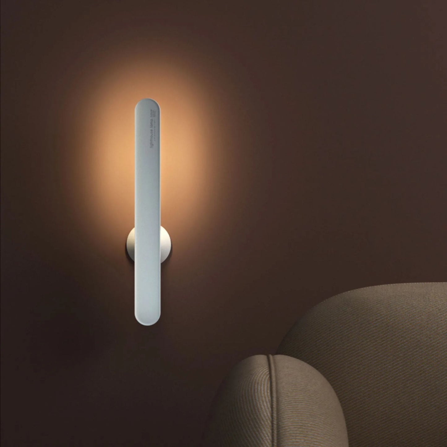 White geometric desk lamp with magnetic base and touch control on a wooden table.
