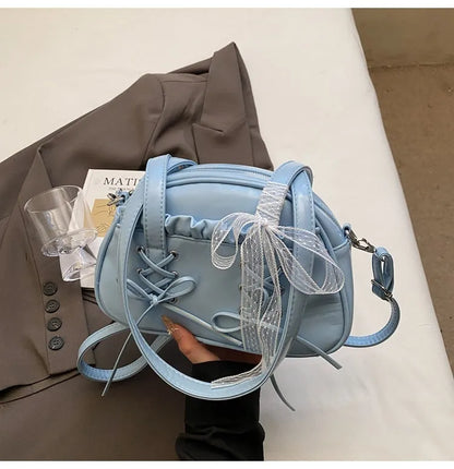 Women's PU leather casual shoulder handbag with a large bandage bow and sewing thread detail.