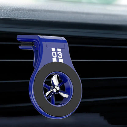 Black magnetic car phone holder attached to air vent with phone mounted and fragrance slice visible