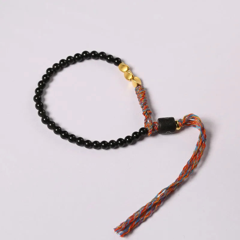 Close-up of a hand-woven obsidian bracelet with a 4mm wide strap on a wrist.
