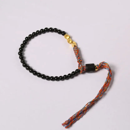 Close-up of a hand-woven obsidian bracelet with a 4mm wide strap on a wrist.