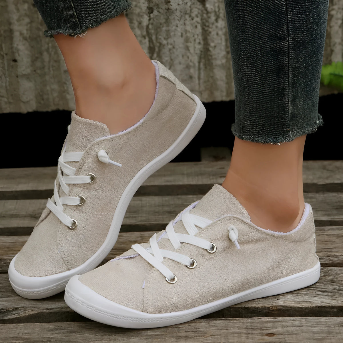 Women's creamy white low-top casual sneaker with fabric upper and rubber sole.