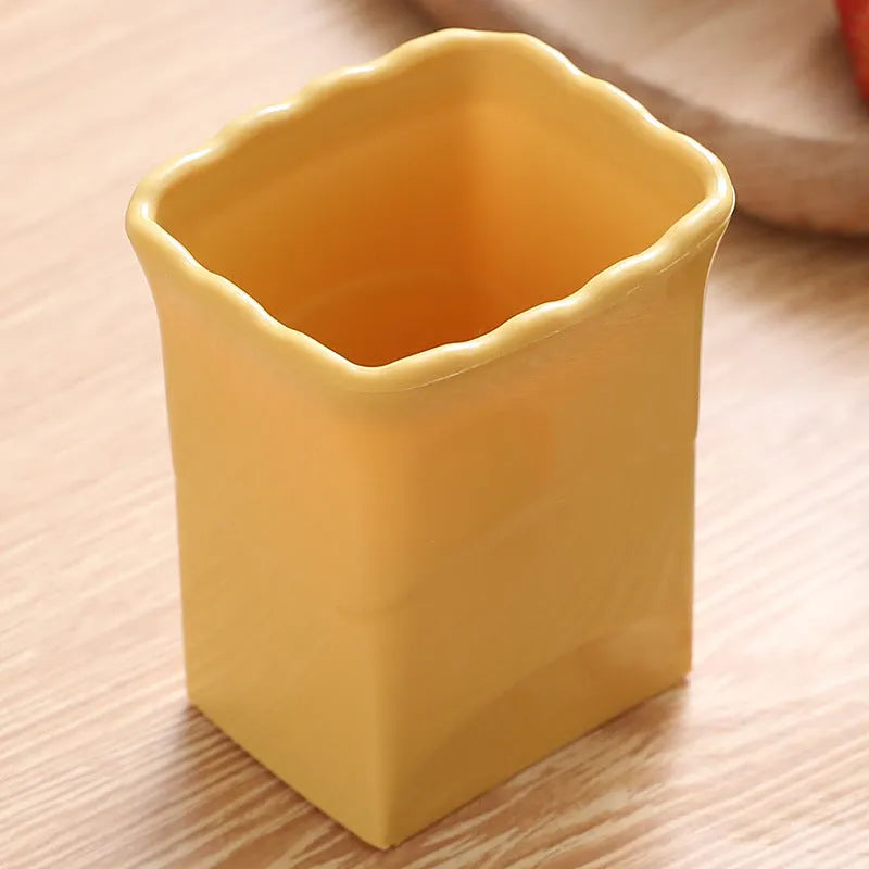 Green stainless steel cup-shaped kitchen slicer for cutting fruits and eggs on a countertop.