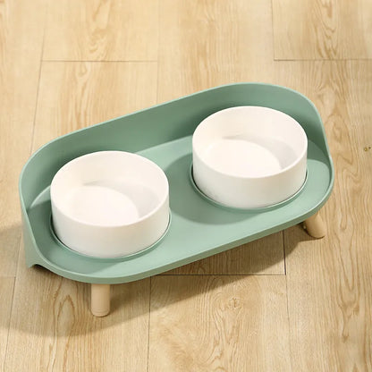 Green tilted pet feeder with adjustable stainless steel frame and two food bowls for cats and dogs
