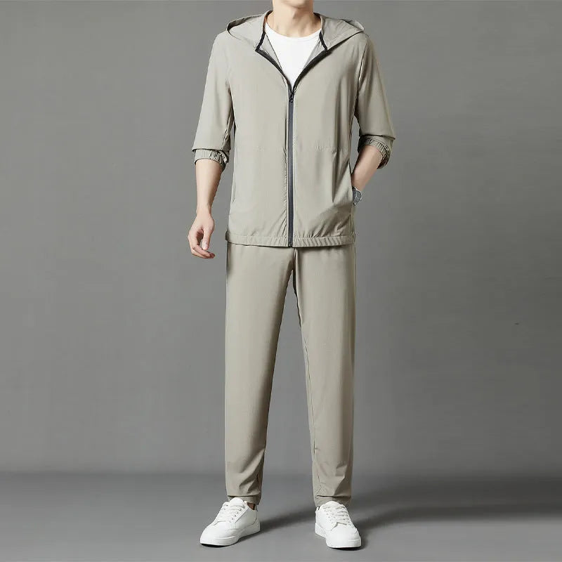 Grey hooded sun-protective top and loose pants suit for men on a hanger.