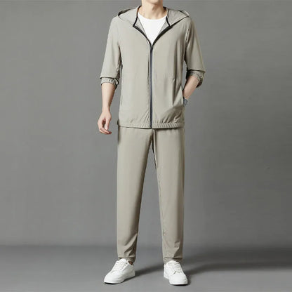 Grey hooded sun-protective top and loose pants suit for men on a hanger.