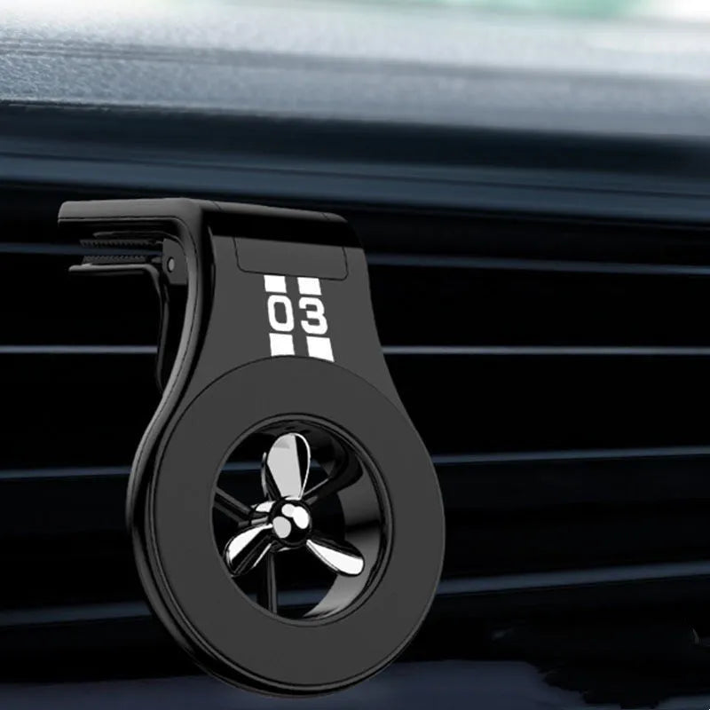 Black magnetic car phone holder attached to air vent with phone mounted and fragrance slice visible