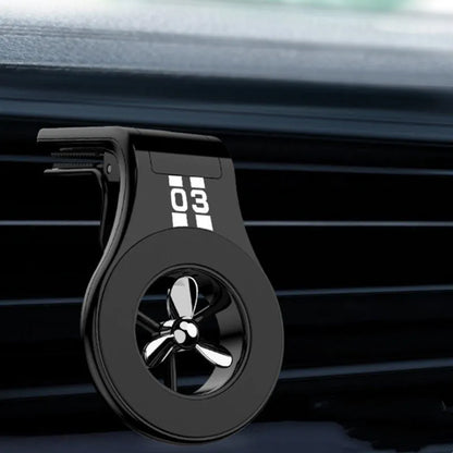 Black magnetic car phone holder attached to air vent with phone mounted and fragrance slice visible