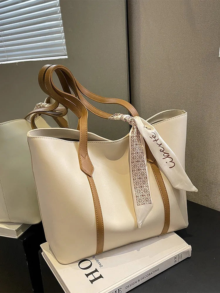 Tote bag with large capacity for casual and versatile wear, a fashionable bucket-style crossbody shoulder bag with an outer sandwich pocket and internal zipper compartment, available in black, khaki, white and pink, white with brown, and white with green.