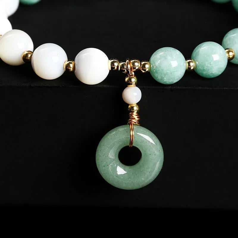 Blue Burma jade bead bracelet with copper horseshoe screw safety buckle on a wrist.