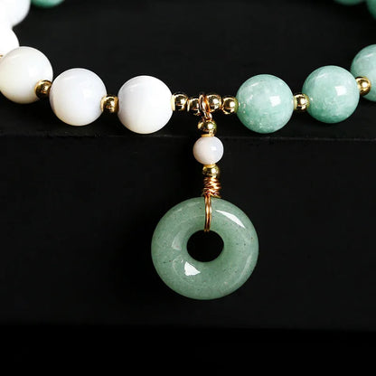 Blue Burma jade bead bracelet with copper horseshoe screw safety buckle on a wrist.