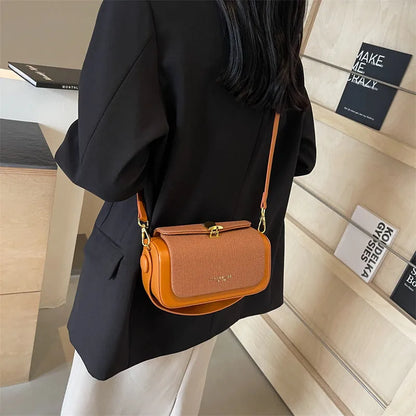 Women's PU leather messenger bag in a horizontal square shape with a lock and adjustable shoulder strap.