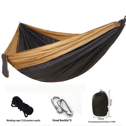 Parachute cloth double camping hammock in chosen colour, with black buckles and round ropes on a tree.
