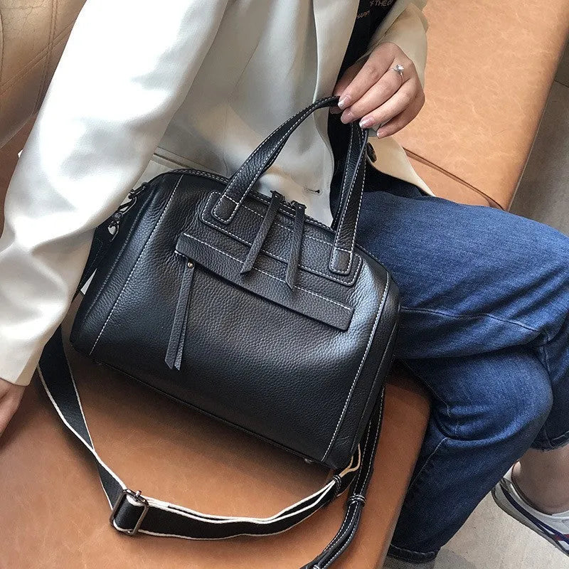 Genuine leather horizontal messenger bag in wine red with shoulder strap and internal zippered compartments.
