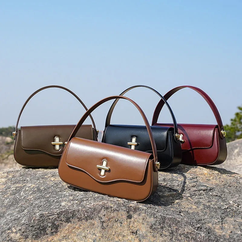 Genuine leather baguette handbag in horizontal square shape with clamshell opening and internal zip compartments