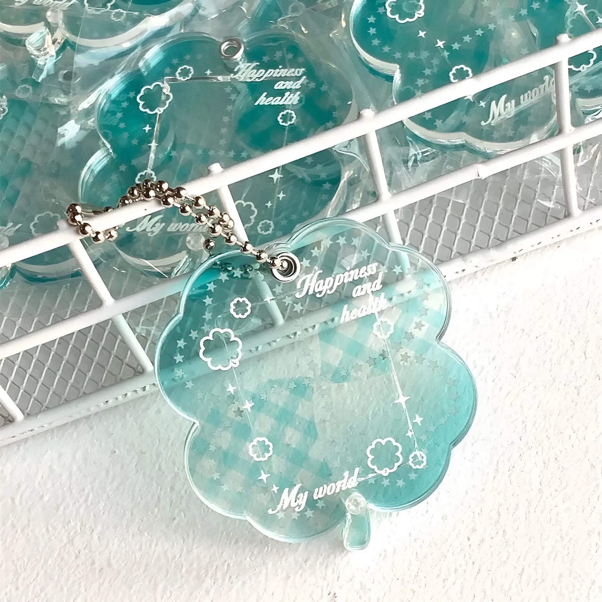Four-leaf clover shaped acrylic phone pendant keychain in blue, green, and mint colour options