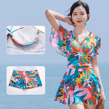 Women's colourful printed one-piece swimsuit on a mannequin, showing full coverage design.