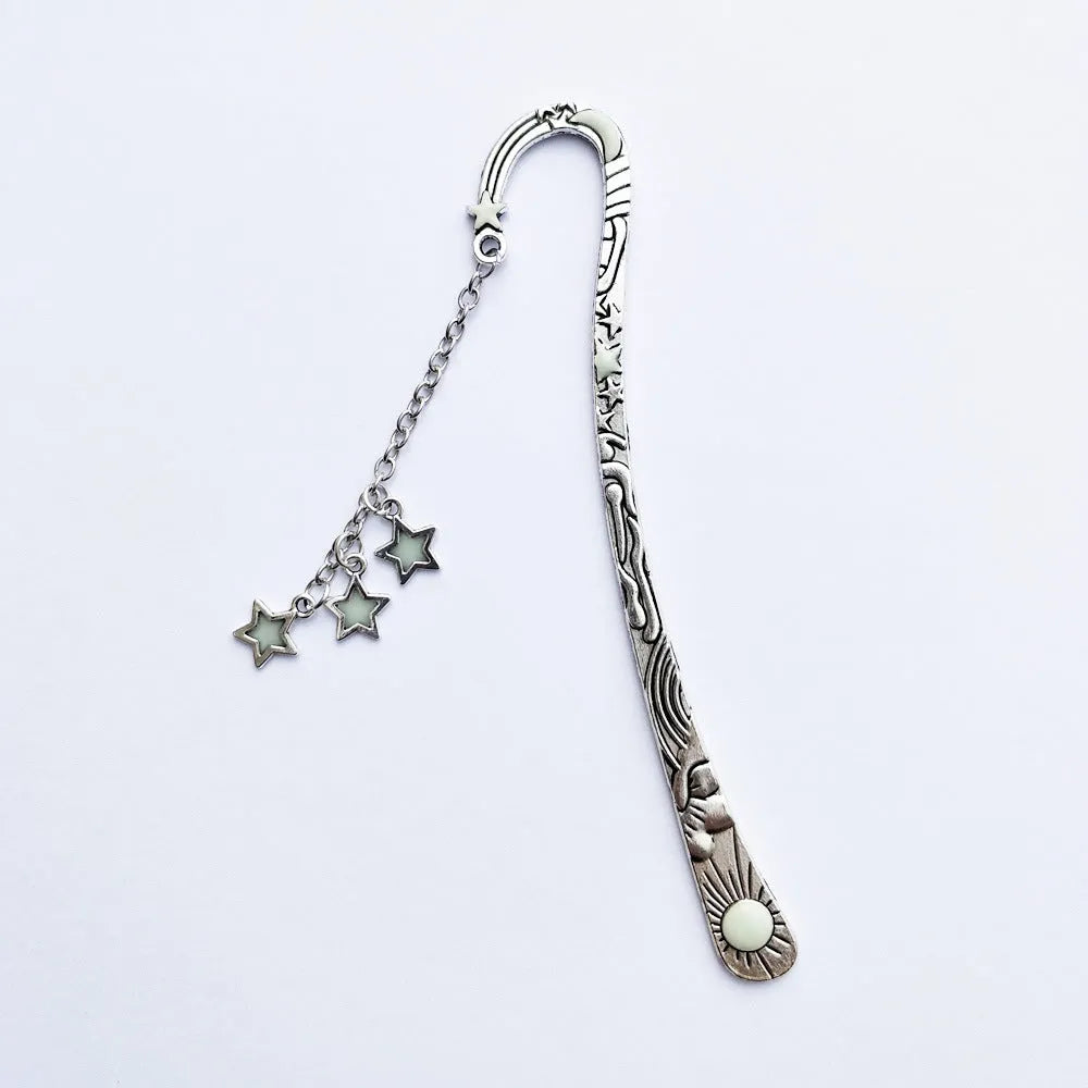 Retro five-pointed star glowing metal bookmark in ancient silver and bronze finishes on an open book.