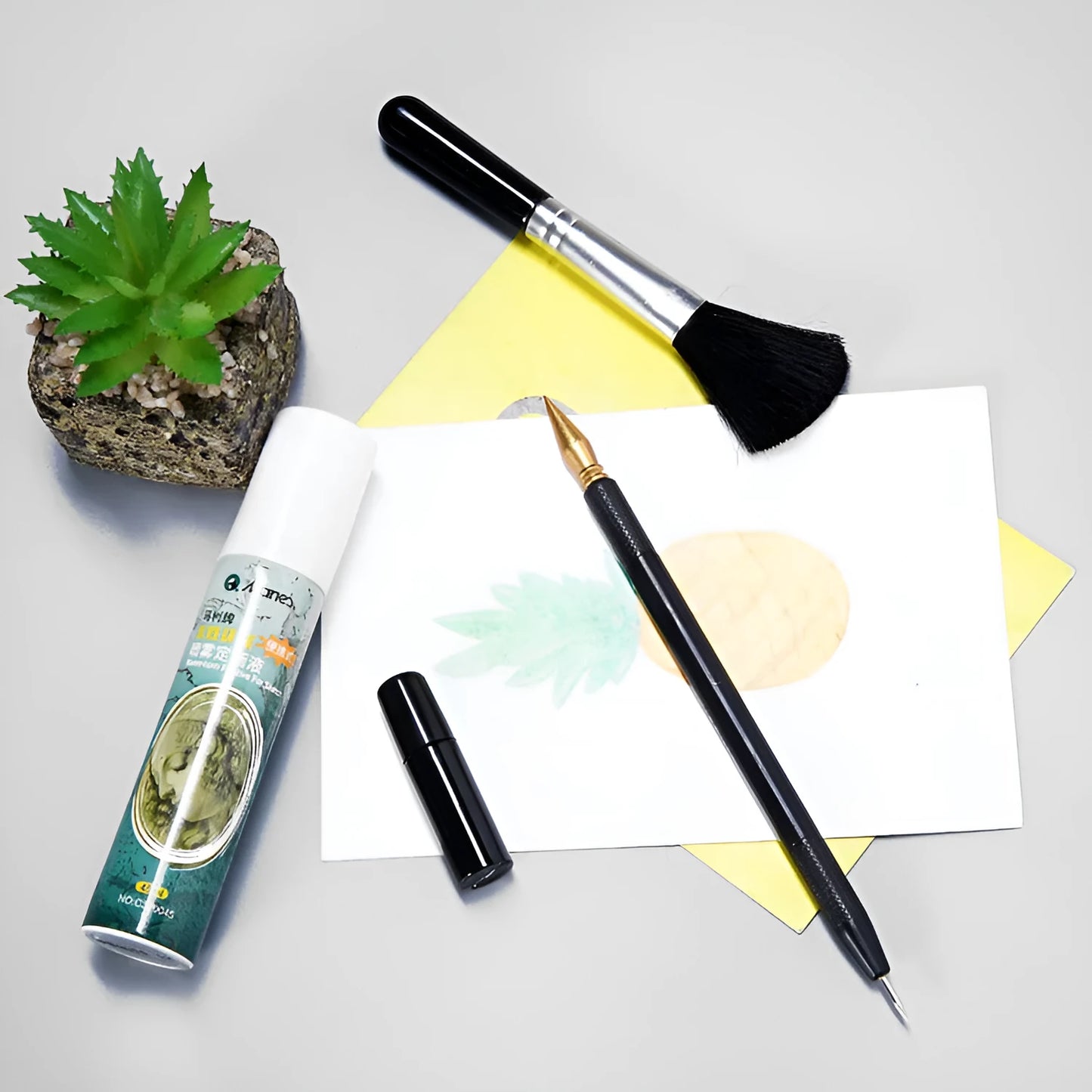 Diamond painting repair tool set with metal scraper pen, bottle of adhesive liquid, soft brush, and bamboo stick on a craft table