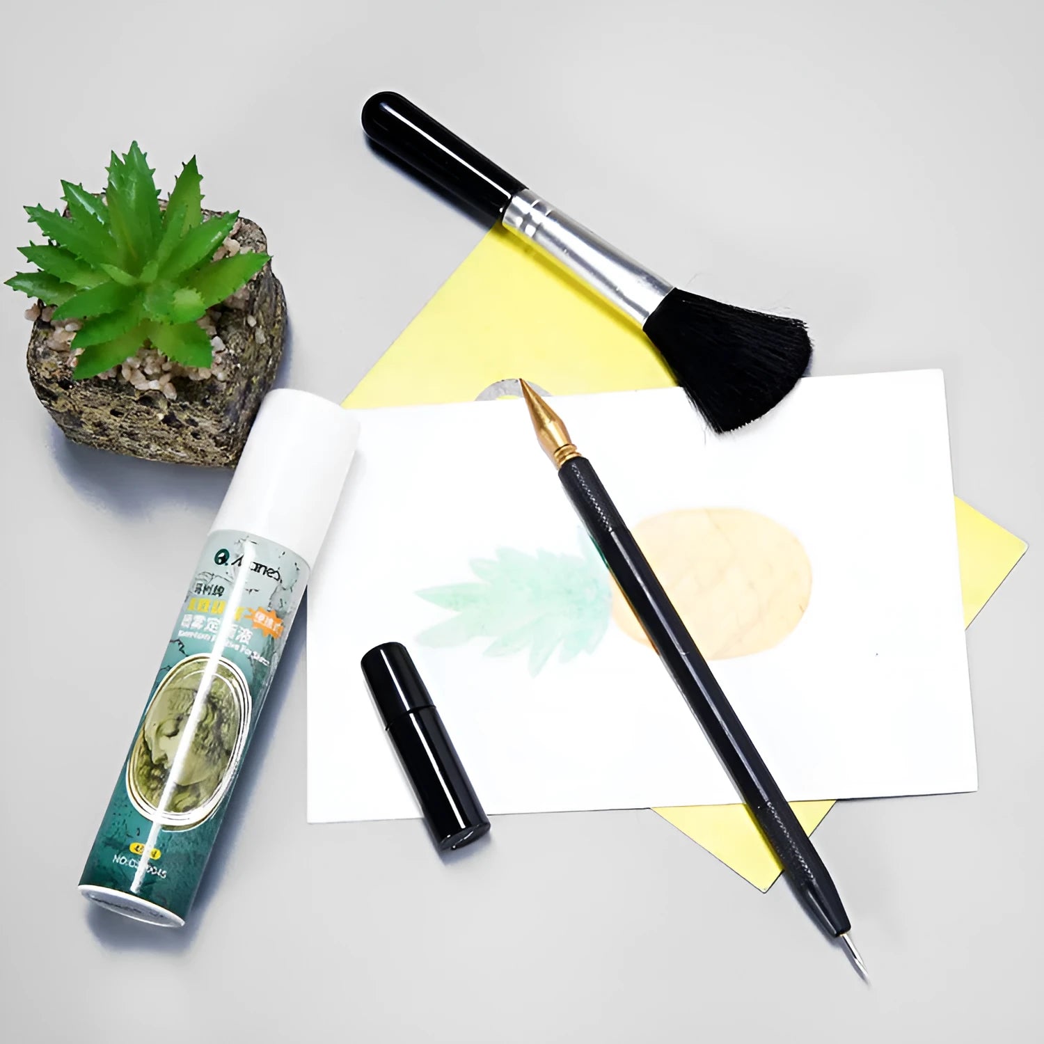 Diamond painting repair tool set with metal scraper pen, bottle of adhesive liquid, soft brush, and bamboo stick on a craft table