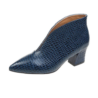Women's black V cut Martin boots with a pointed embossed toe and a chunky heel.