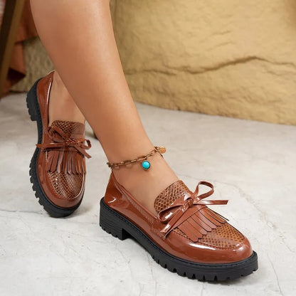 Women's brown artificial PU loafers with a bow detail on the pointed toe, shown on a size label.