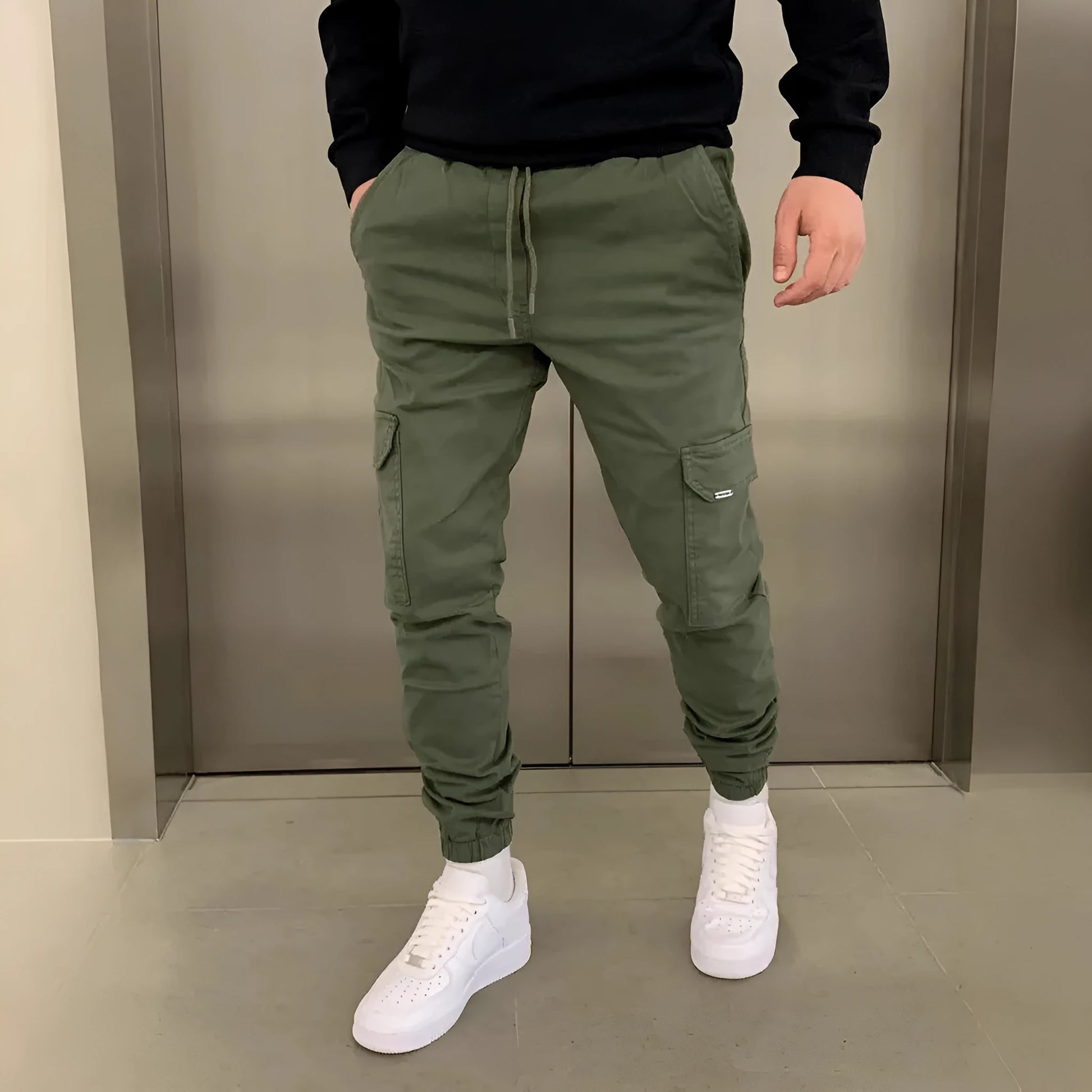 Men's light blue polyester loose-fit straight-leg trousers with dimensional patch pockets and elastic waistband laid flat.