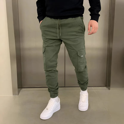 Men's light blue polyester loose-fit straight-leg trousers with dimensional patch pockets and elastic waistband laid flat.